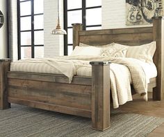 a bed sitting in a bedroom on top of a wooden floor next to a window