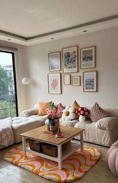 a living room filled with lots of furniture and pictures hanging on the wall above it