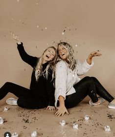 two women sitting on the floor with confetti all around them