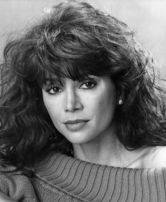 black and white photograph of a woman with long curly hair wearing a turtle neck sweater