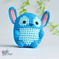 a small crocheted blue and white elephant with ears on it's head