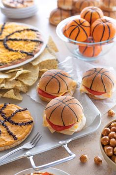 basketball themed sandwiches and snacks are on the table with utensils, plates and bowls