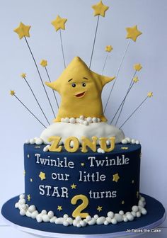 a blue and white cake with yellow stars on the top that says, zoid twinkle twinkle our little star 2 turns