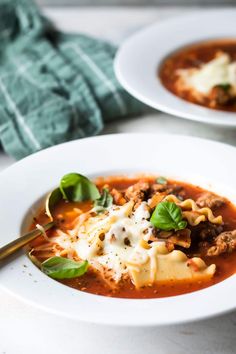 a white bowl filled with pasta and meat soup