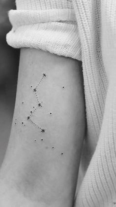 a woman's arm with a small star tattoo on the left side of her wrist