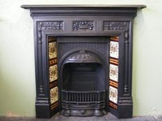 an antique fireplace with decorative tiles on the top and bottom part, painted in black