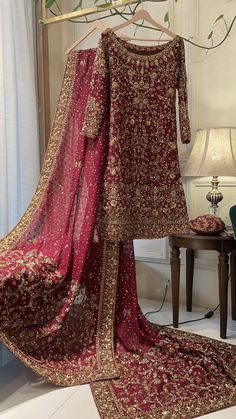 a red and gold dress on display in front of a mirror