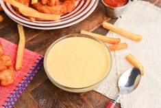 a table topped with french fries next to a bowl of dipping sauce and a plate of chicken nuggies