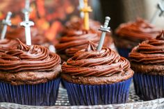 cupcakes with chocolate frosting and crosses on them sitting on a glass plate