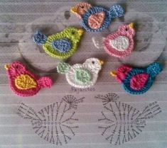 four crocheted birds sitting next to each other on top of a piece of paper