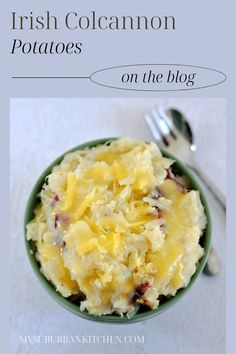 a green bowl filled with mashed potatoes on top of a white table