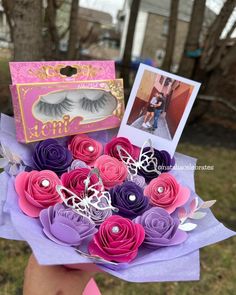 a person holding a bouquet of fake flowers and an open box with eyelashes on it