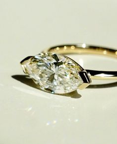 a close up of a diamond ring on a white surface