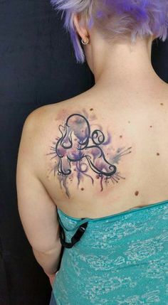 the back of a woman's shoulder with an octopus tattoo on it