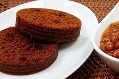 two cookies are on a plate next to a bowl of beans