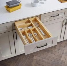 an open drawer in a kitchen filled with utensils