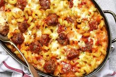 a large casserole dish with meatballs and pasta in it on a table