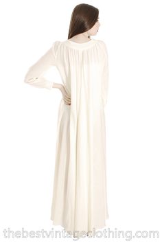 "Vintage Vuokko Nurmesniemi full length maxi dress of ivory or off white pure new wool voile with a super full sweeping hemline and bias cut style. It is a gown that can be worn loose, or belted for a different look. It WOULD make a beautiful wedding gown. Vuokko Nurmesniemi was a principal designer for Marimekko, and known for bold color and shape combinations, whimsical looks. Marked Size: xxs but measurements show it will fit up to a large Bust: 48\" Waist: Free Hips: Free Shoulders: 15\" Sle Cream Long Maxi Dress For Daywear, Cream Long Maxi Dress For Wedding, Off White Maxi Dress For Daywear, Cream Maxi Length Gown, White Modest Maxi Dress For Formal Occasions, Formal Off White Maxi Dress, Off White Floor-length Maxi Dress, Off-white Long Sleeve Maxi Dress For Wedding, Tea Gown