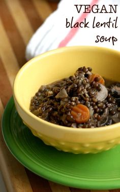 a yellow bowl filled with black lentils and carrots