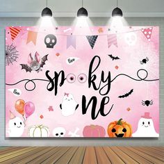 a pink wall with halloween decorations on it and the words spooky me written in black