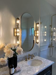 a bathroom with marble counter tops and gold fixtures