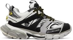 Low-top layered mesh, faux-leather, and rubber sneakers in grey, white, and black. Stripes in yellow throughout. Embroidered number and embossed logo at round toe. Lace-up closure in black and yellow. Webbing pull-loop and embossed logo at padded tongue. Padded collar. Webbing pull-loop and rubberized logo patch at heel collar. Logo printed at outer side. Tonal sculptural foam rubber midsole featuring translucent trim in grey at heel. Treaded rubber outsole in grey.Supplier color: Grey/Yellow Embroidered Number, Balenciaga Track 2, Rubber Sneakers, Balenciaga Clothing, Popular Sneakers, Balenciaga Track, Designer Sneakers, Embossed Logo, Casual Shoes Women