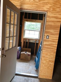 an open door leading to a room that is under construction with boxes and other items on the floor