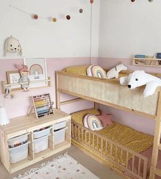 two wooden bunk beds in a pink and white girls'room with toys on the floor