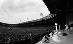 a large crowd at a concert in front of a stage with two people on it