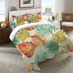 a bed covered in a colorful comforter next to a window with an ocean view