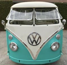 a blue and white vw bus parked on the street