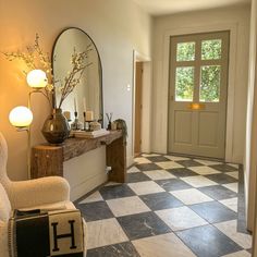 a room with a checkered floor and a large mirror on the wall next to it