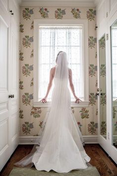 a bride standing in front of a window