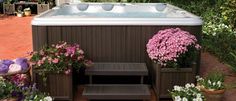 a hot tub surrounded by potted plants and flowers