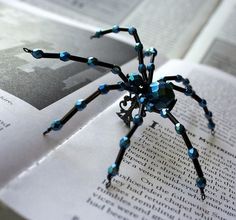 a blue spider sitting on top of an open book