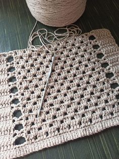 a crocheted placemat with a pair of scissors on it next to a ball of yarn