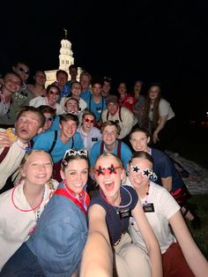 a group of young people posing for a photo at night with one person taking a selfie