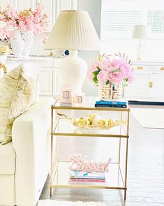 a living room filled with furniture and flowers on top of a table next to a white couch