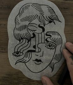 a person is drawing on a stone with black ink