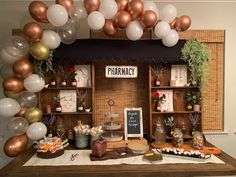 a table topped with lots of white and gold balloons next to shelves filled with items