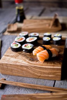 sushi on a wooden cutting board with chopsticks