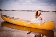 a woman sitting in a yellow canoe on the water