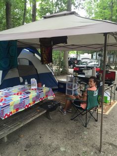 a person sitting in a chair under a tent