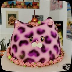 a pink and purple cat cake on top of a table