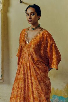 Ochre orange kaftan with all over bandhani blossom print, floral aari, sequins, gota, dori, anchor and zardozi hand embroidered highlights on the plunging V neckline and cascading cowl drapes on the sides. - Aza Fashions Orange Kaftan, Kaftan Pattern, Kaftan For Women, Printed Kaftan, Mixed Prints, Blossom Print, Dupion Silk, Luxury Sale, Embroidered Neckline