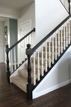 a white staircase with black railing and wood handrails in a new build home