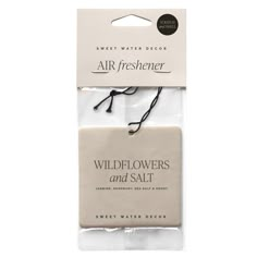 two packaged air fresheners in white packaging with black string on each side and the words, wildflowers and salt