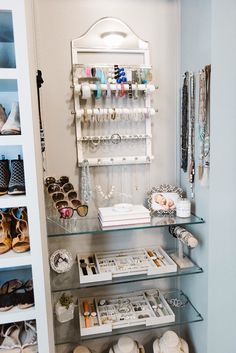 a closet filled with lots of shoes and other items on shelves next to a mirror