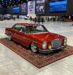 an old red car is on display in a showroom