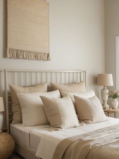 a bed with white linens and pillows in a bedroom